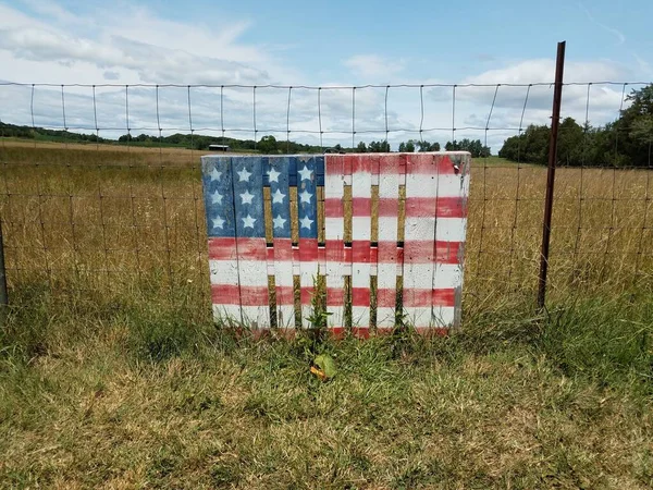Red, white, and blue flag colors on wood with fence and grass — Stock Photo, Image