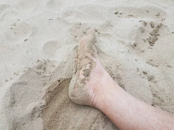 Pies y dedos de los pies masculinos en arena en la playa — Foto de Stock