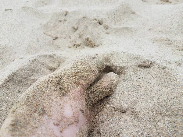 Pies y dedos de los pies masculinos en arena en la playa — Foto de Stock