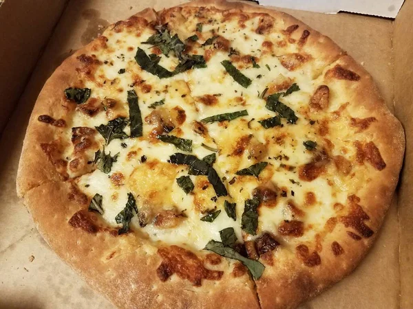 Pequena pizza branca com queijo e manjericão na caixa — Fotografia de Stock