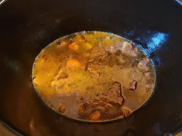 Runderstoofpot met wortelen en bouillon in crockpot — Stockfoto