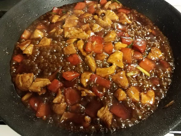 Pollo y pimientos cocinando en sartén con salsa — Foto de Stock