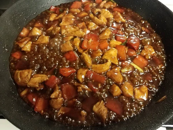 Pollo y pimientos cocinando en sartén con salsa — Foto de Stock