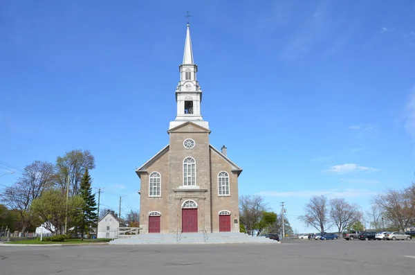 Chiesa grigia in mattoni o pietra con porte rosse in Quebec Canada — Foto Stock