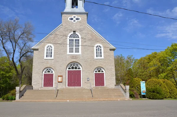 Grey brick or stone church with red doors in Quebec Canada Royalty Free Stock Images