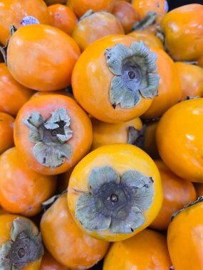 Bir bakkal yığını parlak turuncu hurma ve belirgin gri calyx