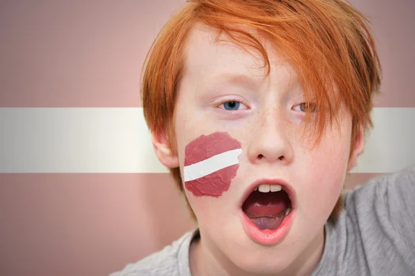 Redhead fan boy with latvian flag painted on his face — Stock Photo, Image