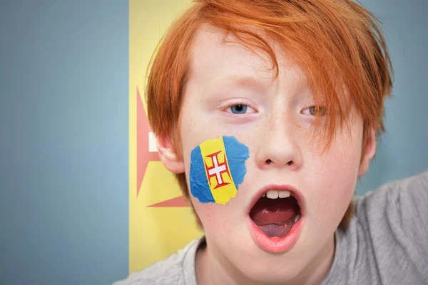 Ventilateur rousse garçon avec drapeau madère peint sur son visage — Photo