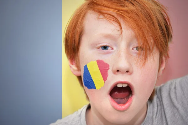 Tifoso rosso ragazzo con bandiera rumena dipinta sul viso — Foto Stock