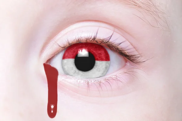 Oeil humain avec drapeau national de l'indonésie avec des larmes sanglantes — Photo