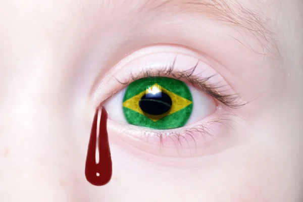 Menschenauge mit brasilianischer Nationalflagge mit blutigen Tränen. — Stockfoto