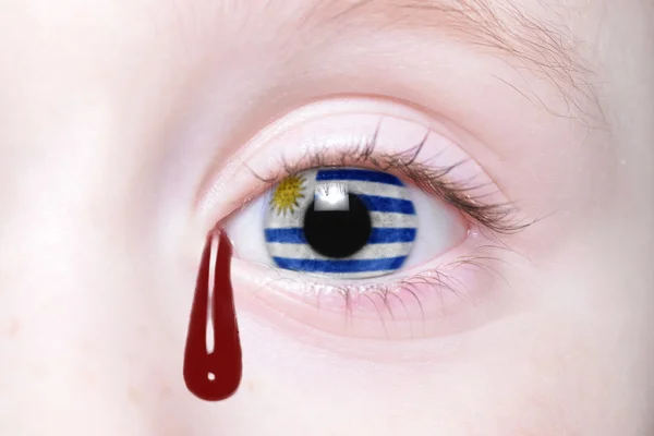 Olho humano com bandeira nacional de uruguai com lágrimas sangrentas . — Fotografia de Stock