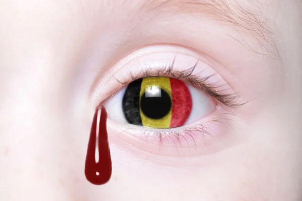 Oko człowieka z flagi narodowej Belgii z krwawe łzy. — Zdjęcie stockowe