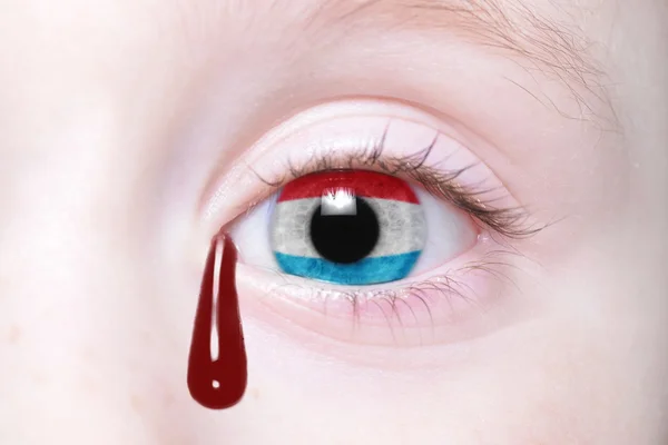 Ojo humano con bandera nacional de Luxemburgo con lágrimas sangrientas . — Foto de Stock