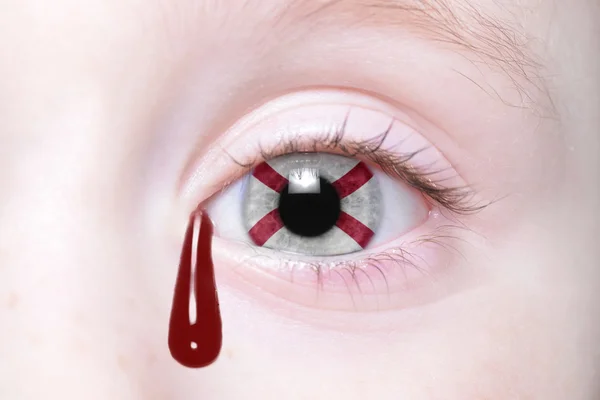 Ojo humano con la bandera del estado de alabama con lágrimas sangrientas — Foto de Stock