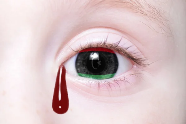 Ojo humano con bandera nacional de libya con lágrimas sangrientas — Foto de Stock