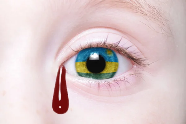 Ojo humano con bandera nacional de Ruanda con lágrimas sangrientas — Foto de Stock