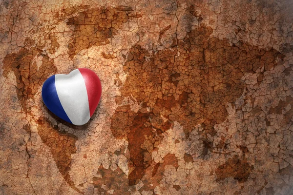 Heart with national flag of france on a vintage world map crack paper background — Stock Photo, Image