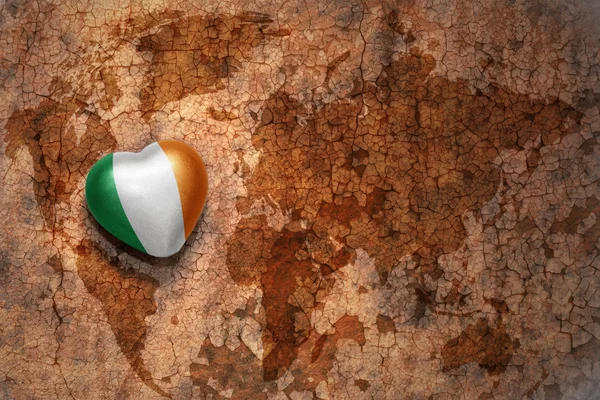 Cuore con bandiera nazionale d'Irlanda su una mappa del mondo vintage crack sfondo di carta — Foto Stock