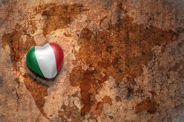 Heart with national flag of italy on a vintage world map crack paper background — Stock Photo, Image