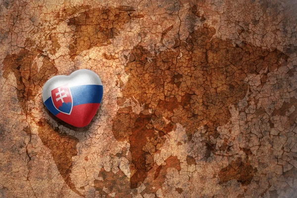 与老式的世界地图裂纹纸张背景上的斯洛伐克国旗的心 — 图库照片