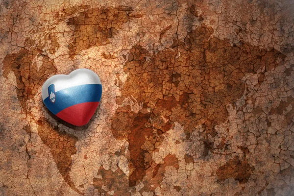 Coração com bandeira nacional de slovenia em um mapa do mundo vintage crack papel fundo — Fotografia de Stock