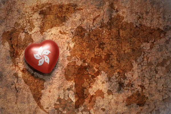 Heart with national flag of hong kong on a vintage world map crack paper background. — Stock Photo, Image