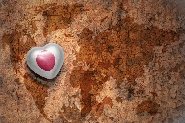 Heart with national flag of japan on a vintage world map crack paper background. — Stock Photo, Image