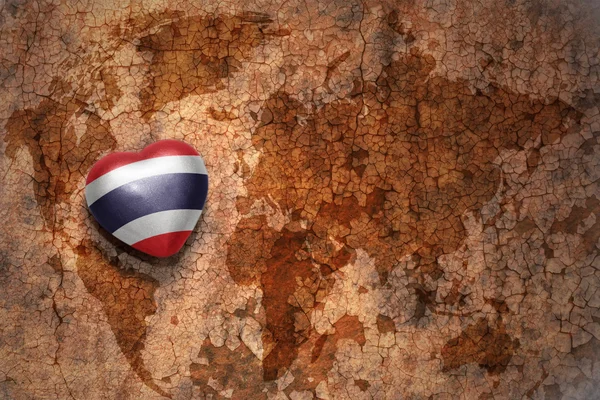 Coeur avec drapeau national de Thaïlande sur fond papier craquelé carte du monde vintage . — Photo