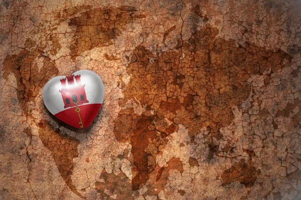 Heart with national flag of gibraltar on a vintage world map crack paper background. concept — Stock Photo, Image