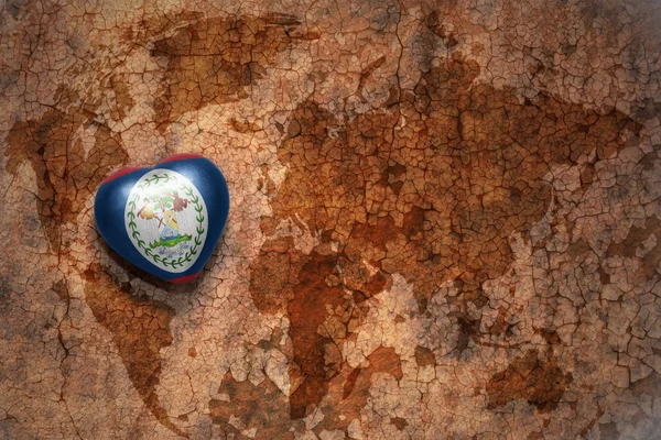 Сердце с национальным флагом Белиза на винтажном фоне карты мира крэк бумаги. концепция — стоковое фото