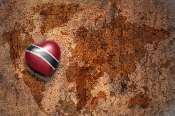 Heart with national flag of trinidad and tobago on a vintage world map crack paper background. concept — Stock Photo, Image