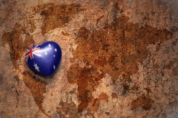 Herz mit australischer Nationalflagge auf einem alten Weltkartenrisspapier-Hintergrund. Konzept — Stockfoto