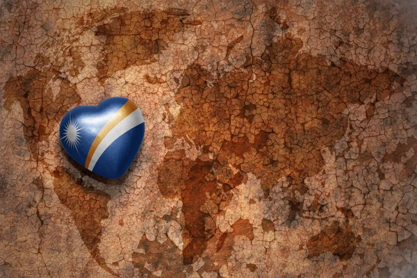 Сердце с национальным флагом Маршалловых Островов на винтажном фоне карты мира крэк бумаги. концепция — стоковое фото