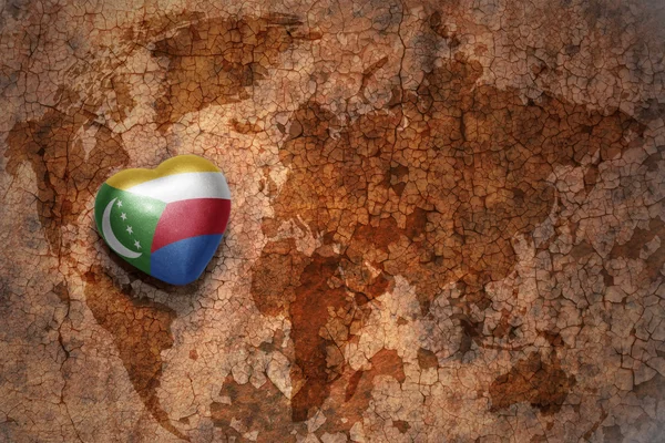 Hart met nationale vlag van de Comoren op een vintage wereld kaart crack papier achtergrond. — Stockfoto