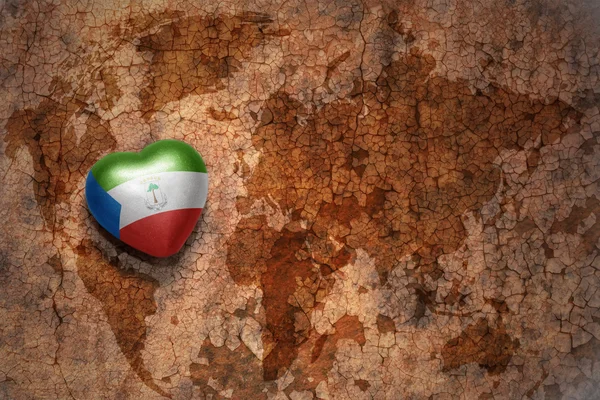 Heart with national flag of equatorial guinea on a vintage world map crack paper background. — Stock Photo, Image