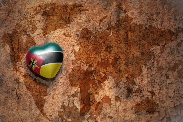 Heart with national flag of mozambique on a vintage world map crack paper background. — Stock Photo, Image