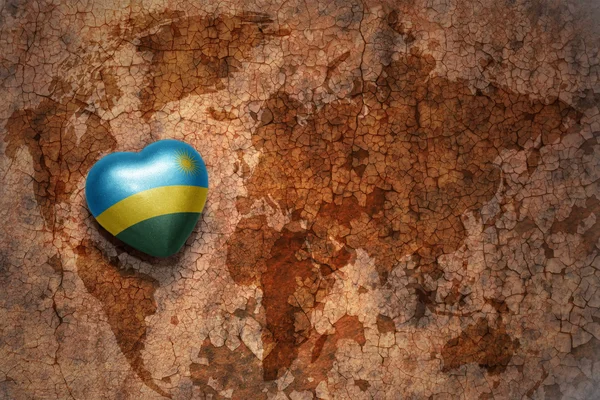 Heart with national flag of rwanda on a vintage world map crack paper background. — Stock Photo, Image