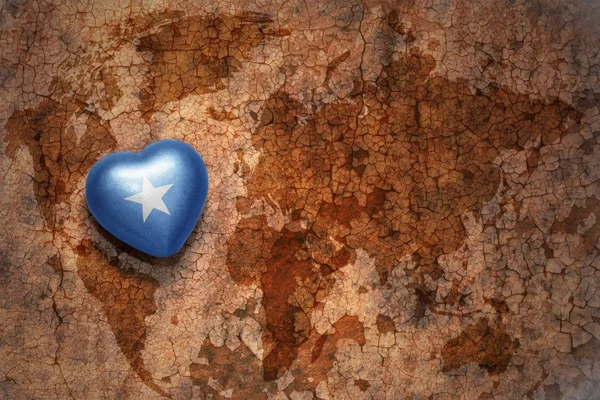 Heart with national flag of somalia on a vintage world map crack paper background. — Stock Photo, Image