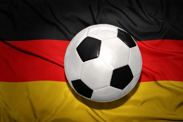 Schwarz-weißer Fußballball auf der deutschen Nationalflagge — Stockfoto