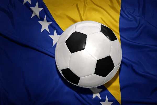 Pelota de fútbol blanco y negro en la bandera nacional de Bosnia y Herzegovina —  Fotos de Stock