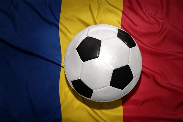 Balón de fútbol blanco y negro en la bandera nacional de romania — Foto de Stock