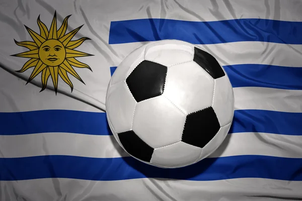 Чорно-білий футбольний м'яч на національному прапорі Уругваю — стокове фото