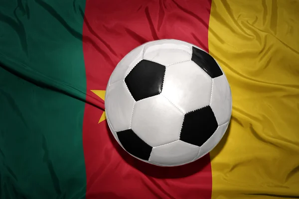 Bola de futebol preto e branco na bandeira nacional dos Camarões — Fotografia de Stock