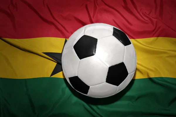 Bola de futebol preto e branco na bandeira nacional do ghana — Fotografia de Stock