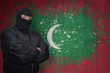 bir maske daimi bir duvar boyalı Maldivler bayrağı ile yakın tehlikeli adam