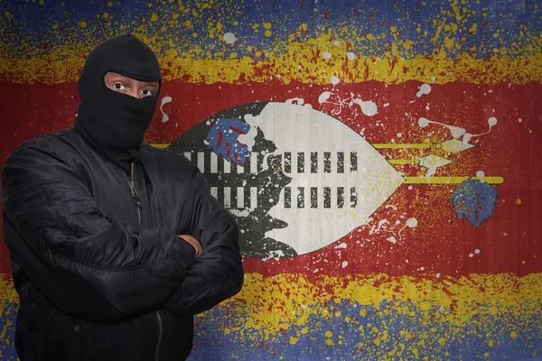 マスク立ってスワジランドの塗られた国旗が付いている壁の近くで危険な男 — ストック写真