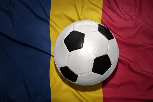 Bola de futebol preto e branco na bandeira nacional do chad — Fotografia de Stock