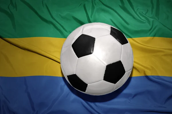 Pelota de fútbol blanco y negro en la bandera nacional de Gabón —  Fotos de Stock