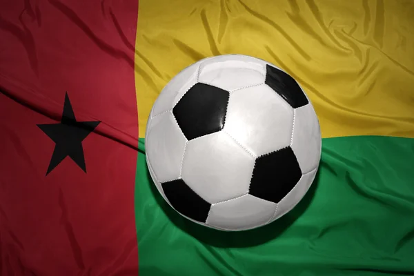 Bola de futebol preto e branco na bandeira nacional da Guiné-bissau — Fotografia de Stock
